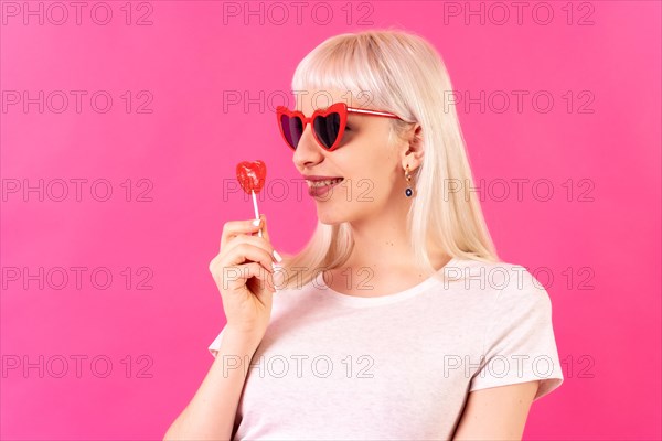 Blonde caucasian girl in studio on a pink background