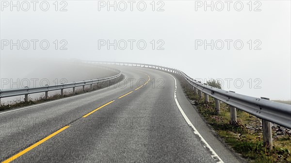 Empty winding road in fog