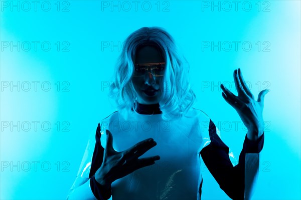 Silhouette of a young woman in futuristic glasses on a blue background