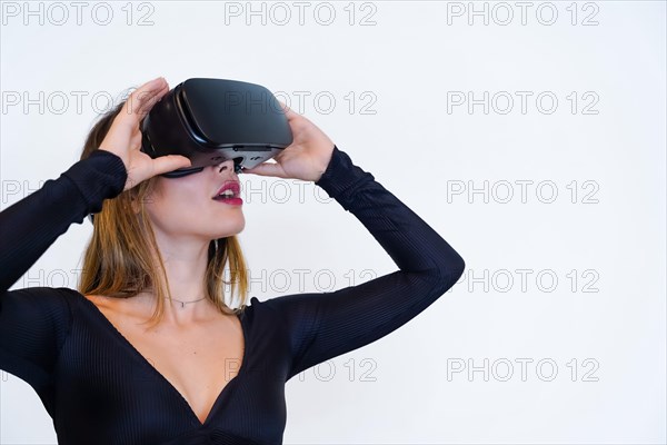 Woman wearing virtual reality goggles on white background