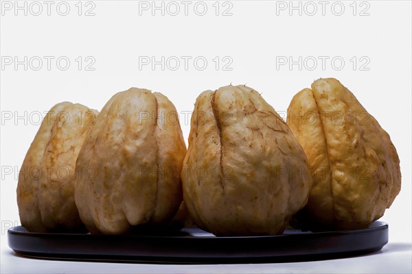 Close-up of chayotes isolated on a white background on a black platter