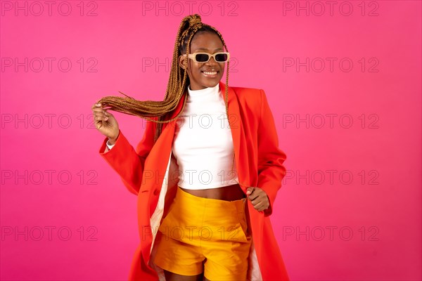 African young woman with braids on a pink background