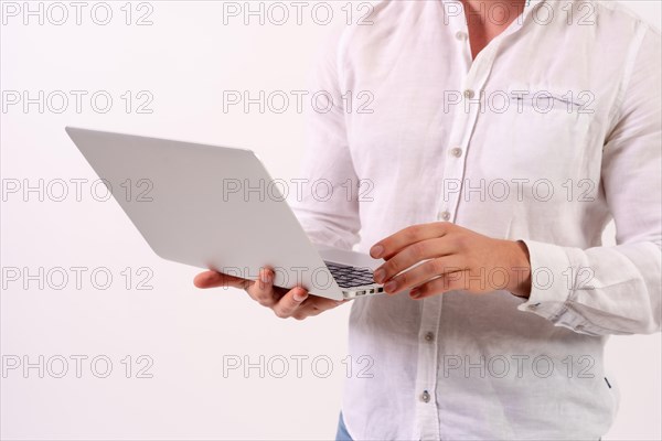 Unrecognizable caucasian businessman with a laptop working on a white background