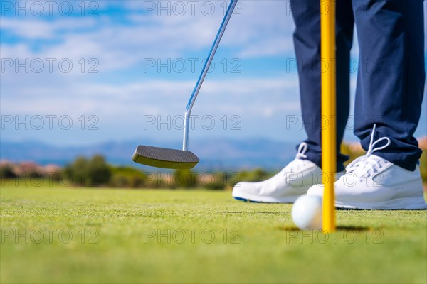 Hitting the green with the putter. The ball in the hole. man playing golf