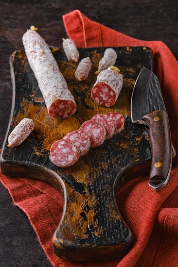 Fermented salami sausages on wooden cutting board cut on slices