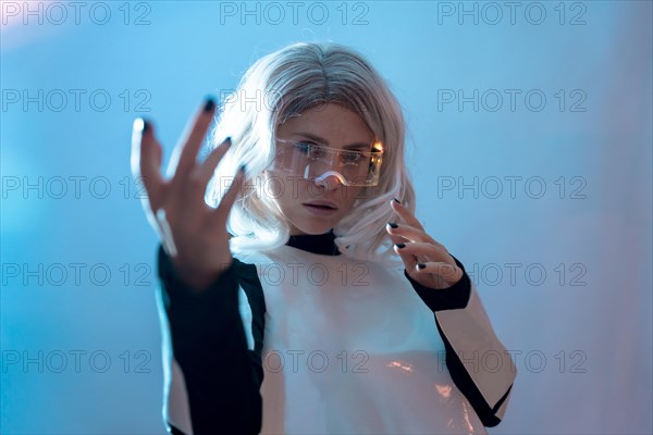 Woman looking through the illuminated futuristic glasses