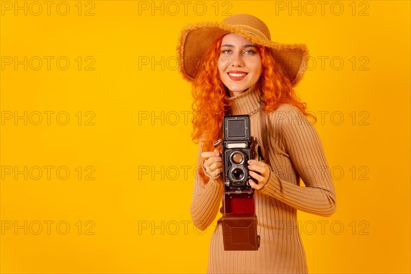 Red-haired woman tourist on a yellow background