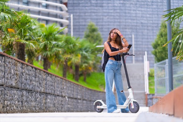 Young woman in the city with an electric scooter