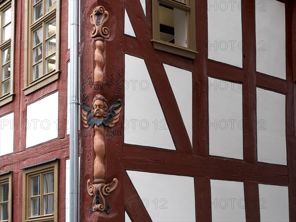 Colourful carved figures on the corner of the half-timbered house