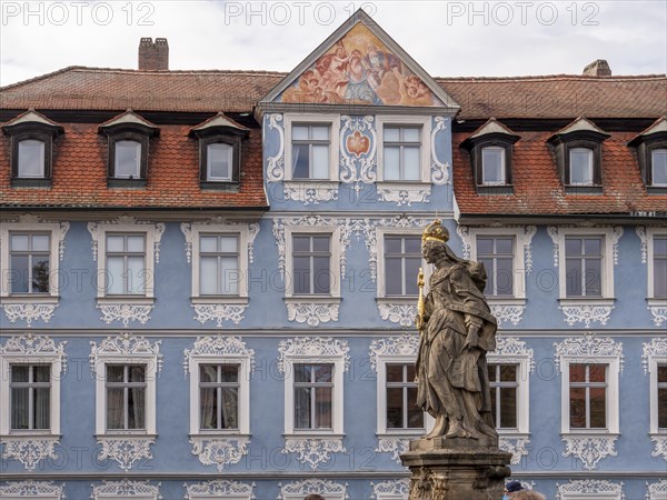 Statue of Empress Kunigunde and behind it the painted blue facade opposite the building Altes Rathaus