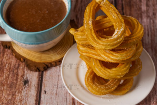 Hot chocolate with churros in a white and blue cup