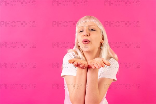 Blonde caucasian girl in studio on pink background