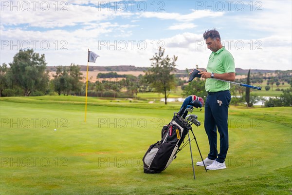 Caucasian professional golf player on the green preparing for the shot