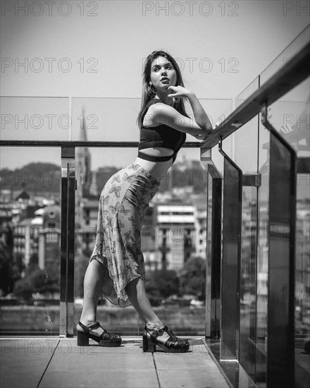 Portrait of a young woman on a hotel terrace looking at the city from above