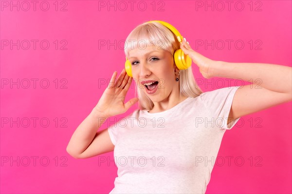 Blonde caucasian girl in studio on pink background