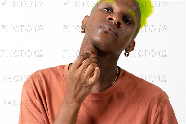 An androgynous black man posing putting on makeup