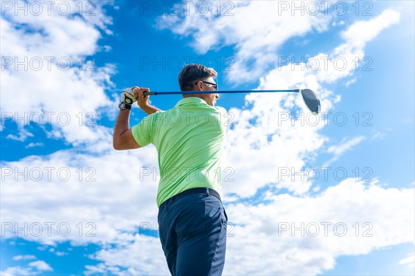 Detail of a golf player on a professional golf course hitting the ball with the stick driver