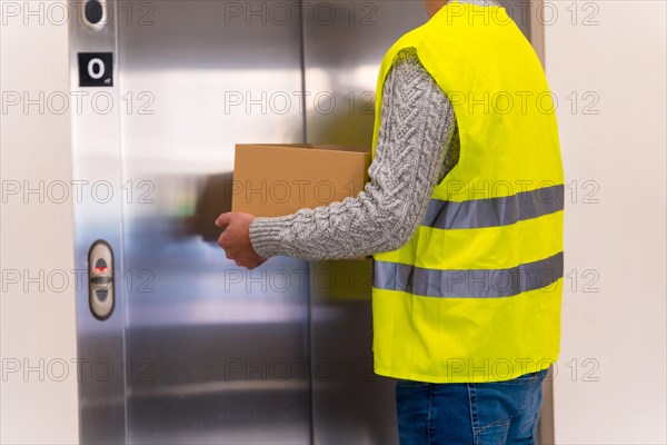 Young delivery man in protective uniform at online order delivery