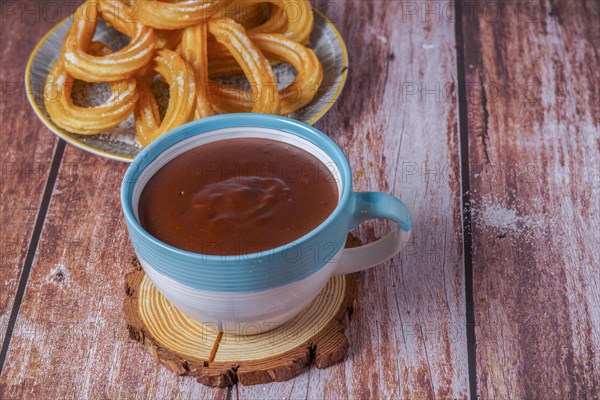 Hot chocolate with churros in a white and blue cup