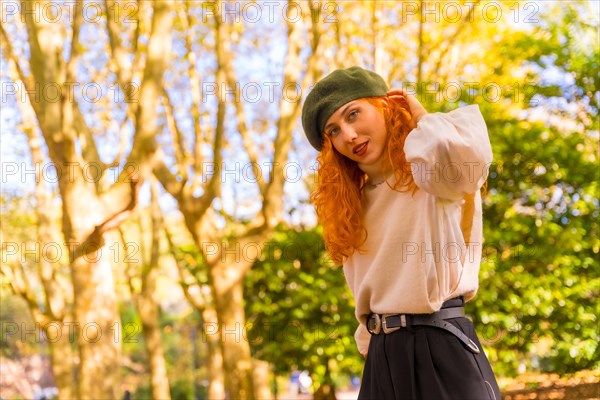 Portrait of red-haired woman with beret in a park