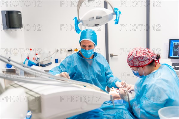 Moment of an oral operation by two dentists on the work table