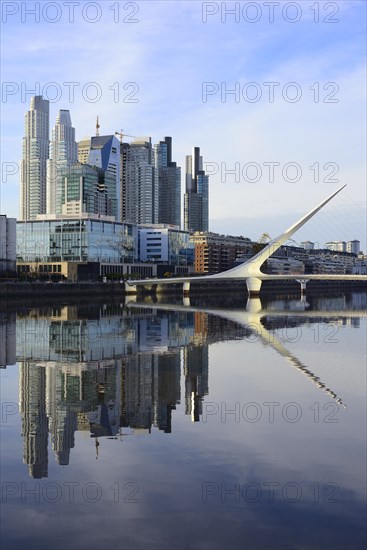 Skyscrapers and the Puente de la Mujer bridge reflected in the water