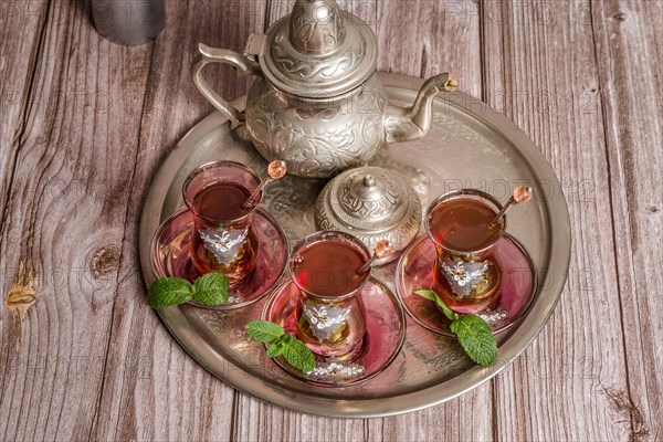 Tray with glasses and serving pitcher of authentic Moorish tea ready to drink with mint leaves