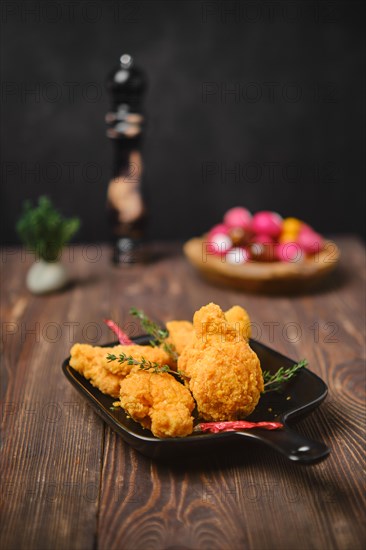 Selective focus photo of deep fried breaded chicken wings on shabby serving board