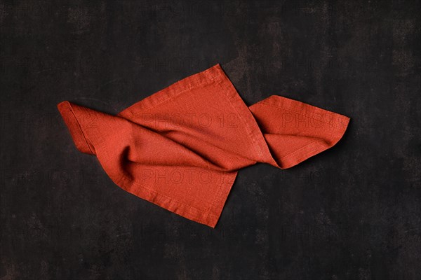 Pale red napkin twisted on dark background