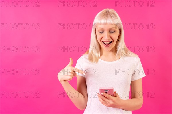 Blonde caucasian girl in studio on pink background