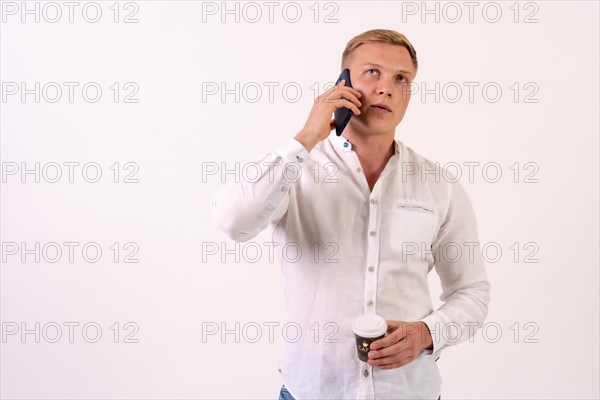 Blond caucasian businessman man making a work call on a white background