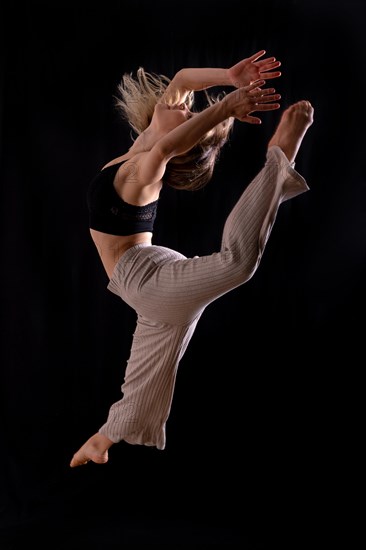 Young dancer in studio photo session with a black background