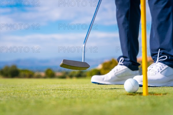 Hitting the green with the putter Putting the ball in the hole. man playing golf