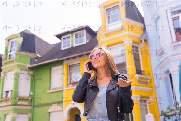 Young blonde with leather jacket sending phone calls