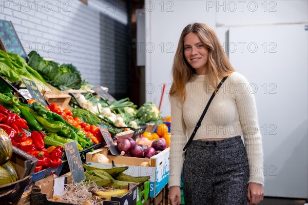 Caucasian woman buying vegetables and greens in grocery store