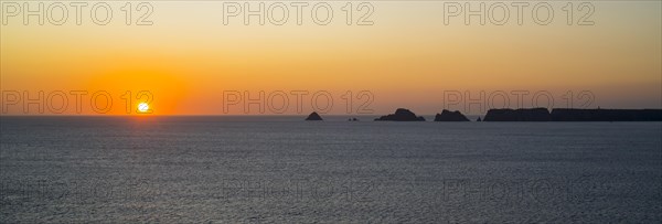 Sea cliffs at the Pointe de Pen-Hir and Les Tas de Pois sea stacks silhouetted against sunset on the Crozon Peninsula