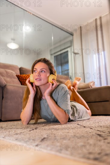 Caucasian woman listening to music lying on the living room carpet