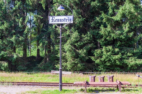 Station lantern with place-name sign and bench made of rusty crash barriers