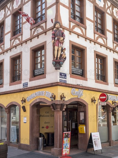 Corner of the half-timbered house with the carved figures of William Tell