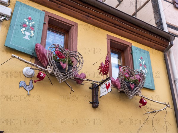 The windows of the yellow building are decorated with colourful hearts