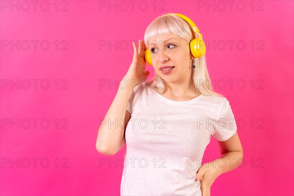 Blonde caucasian girl in studio on pink background