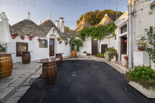 Wine barrels in front of trulli with flowers