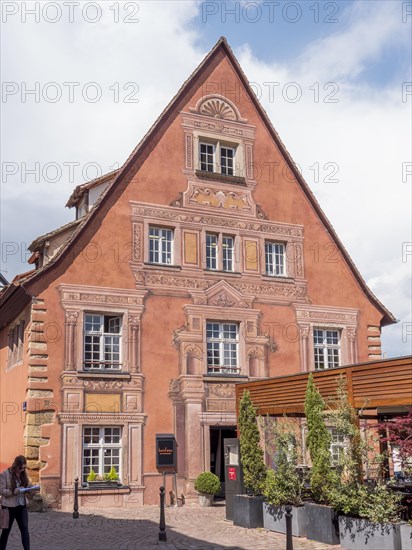 A red building with painted ornaments around the windows and doors in the district of La Petite Venise