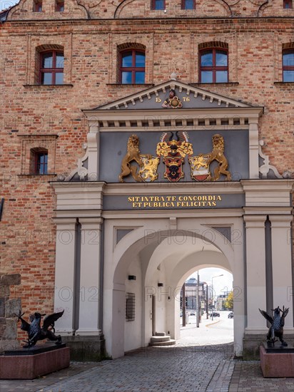 Dragon statues on the side of the entrance through the brick gate and with inscription