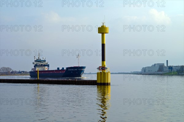 Bremen Vegesack. Cargo ship Terschelling on the Weser. Lighthouse at the mouth of the river Lesu. Germany