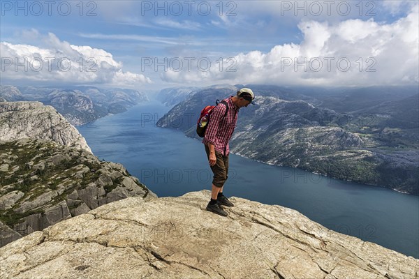 Hiker standing carefully at the rocky outcrop