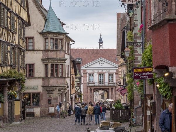 Colourful half-timbered houses and tourists in the Rue du General de Gaulle and in the background town hall Hotel de Ville