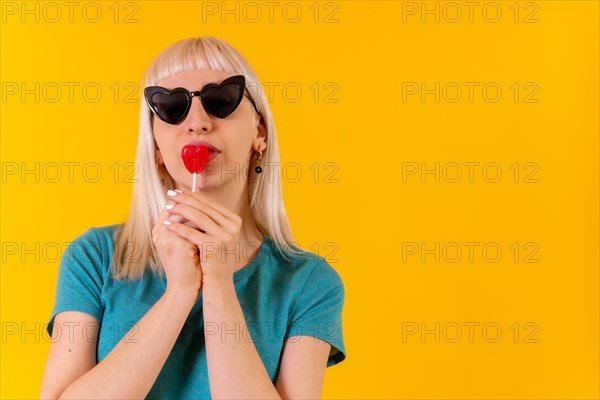 Having fun eating a heart lollipop