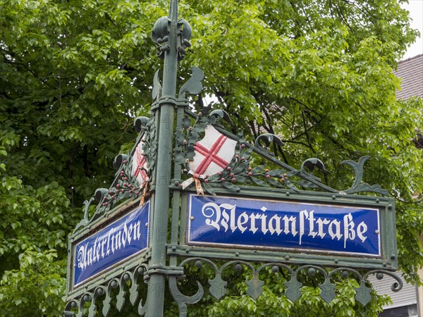 A typical street sign with the city's coat of arms at the intersection of two streets