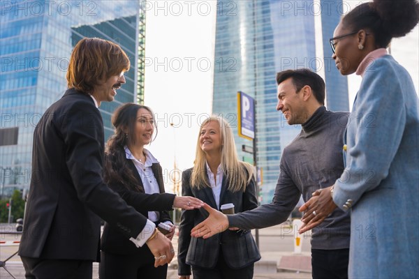 Group of multi-ethnic business people in a business park introducing themselves and shaking hands outdoors